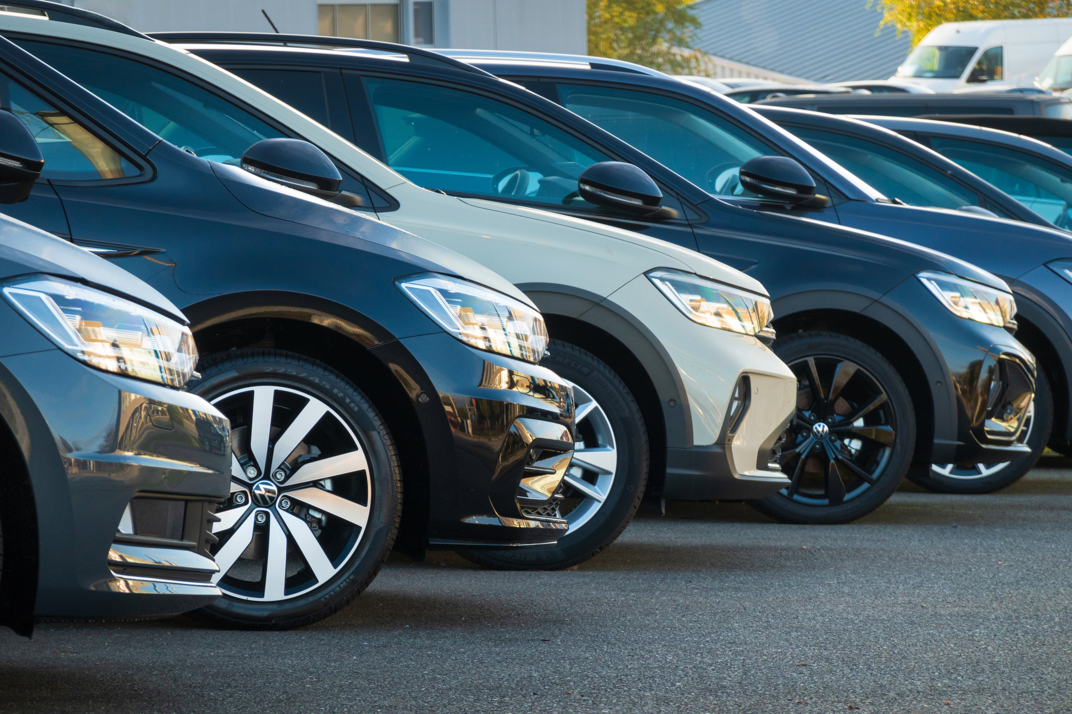 A row of used cars parked at a public car dealership