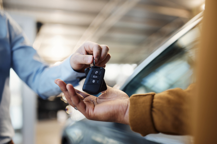 Car Keys being handed to someone from another hand