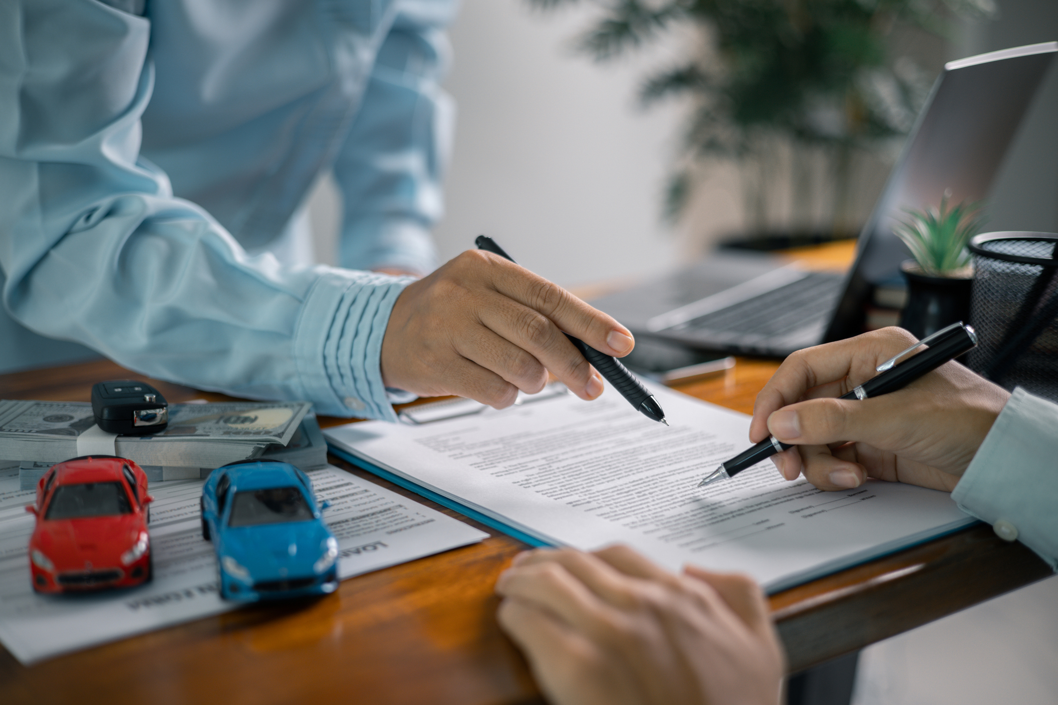 Customers signing a paper getting approved for a car