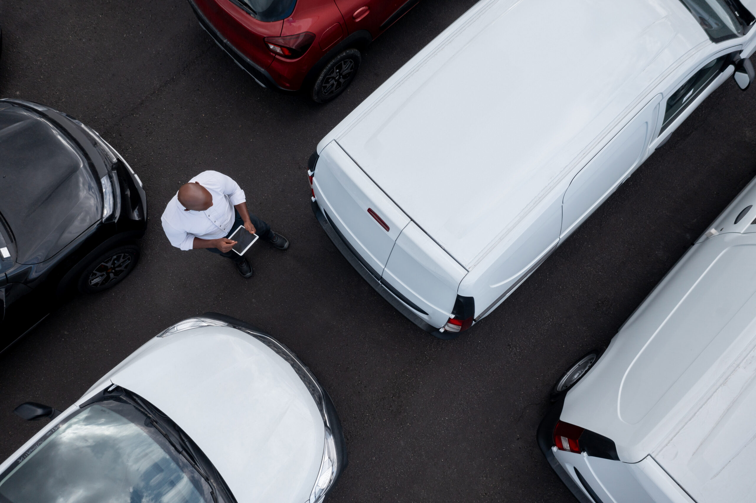 Salesman working at the dealership selling cars and using a tablet computer