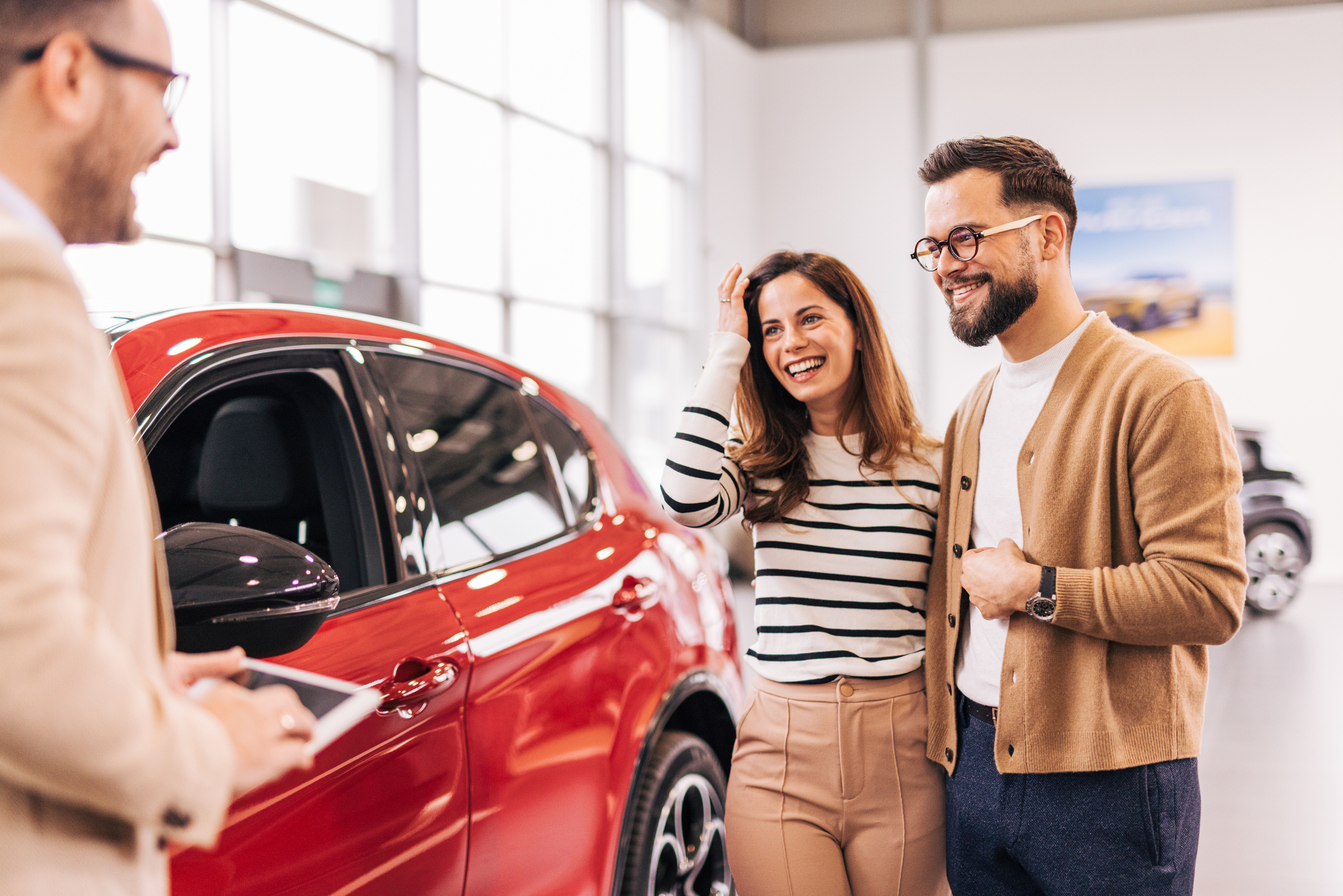 Car salesman discussing contract with couple