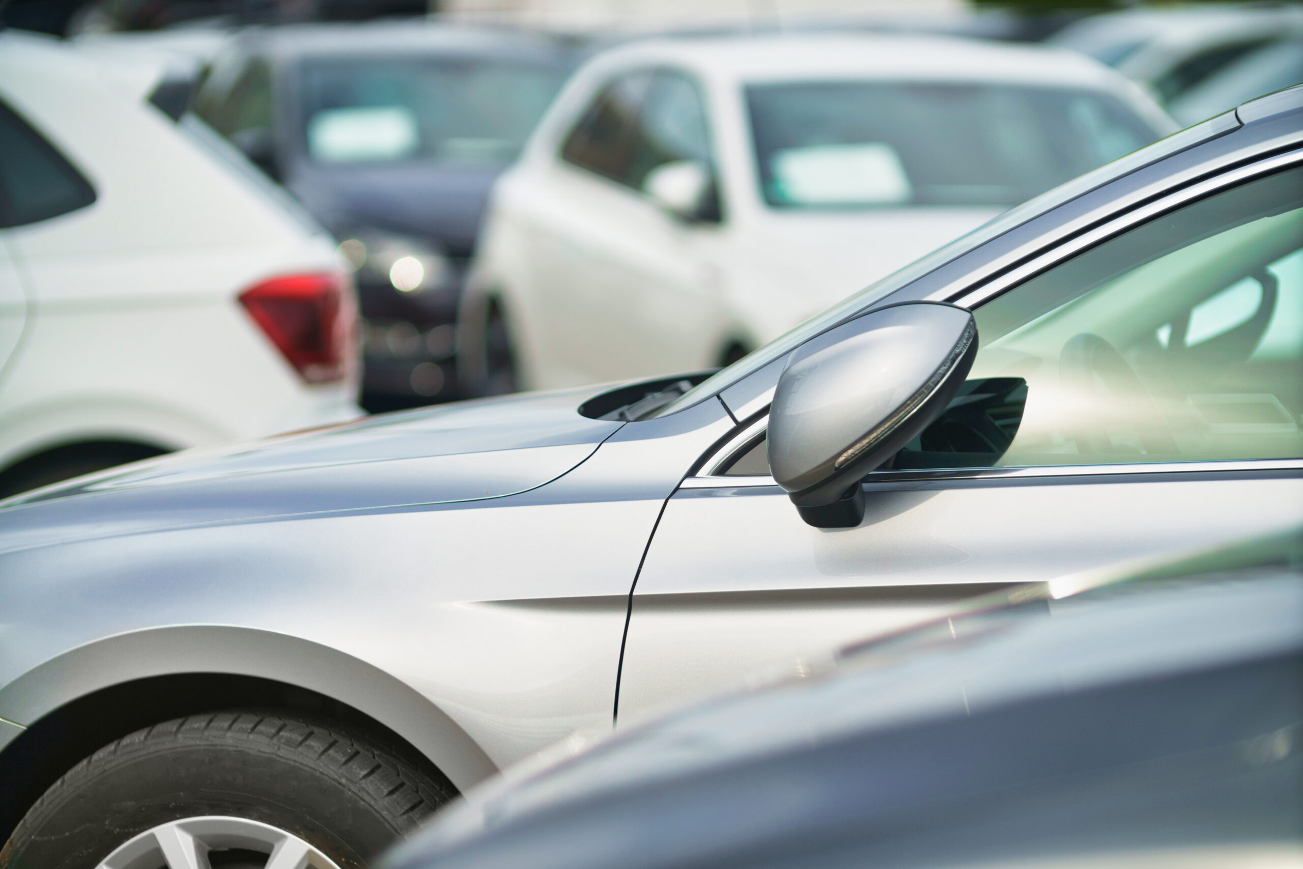Side shot of a range of used modern vehicles, at a public car dealership